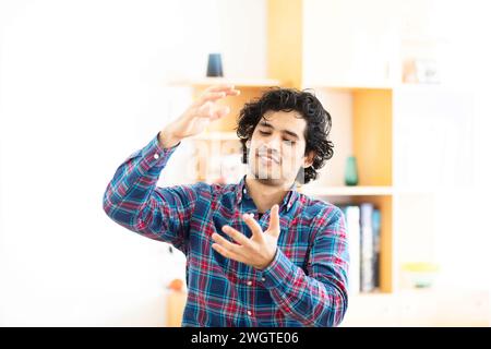 young man at home making signs with the hands Stock Photo
