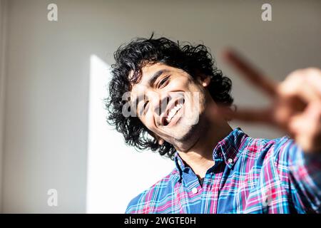 young man at home making signs with the hands Stock Photo