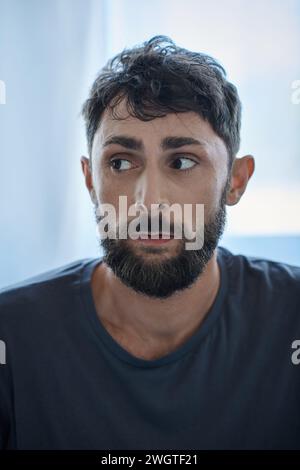 anxious man in everyday t shirt suffering during depressive episode, mental health awareness Stock Photo