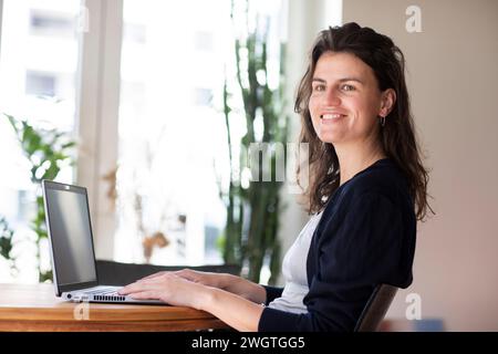 young woman working at home with green plants Stock Photo