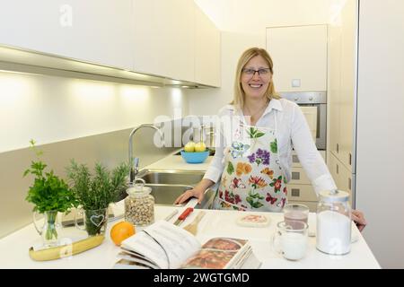 Blonde woman cooking indoors, Milano, Italy. Stock Photo