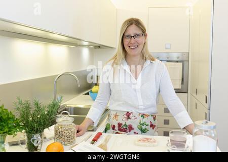 Blonde woman cooking indoors, Milano, Italy. Stock Photo