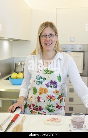 Blonde woman cooking indoors, Milano, Italy. Stock Photo