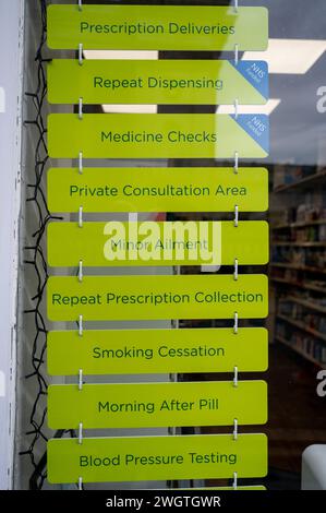 Signs in a chemists of pharmacy shop window offering private healthcare consultations and treatments by pharmacist. Stock Photo