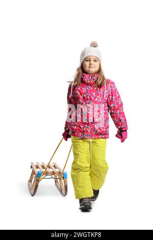 Little girl in a winter clothes pulling a wooden sled isolated on white background Stock Photo