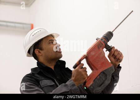 Engineer with helmet, portrait with a drill Stock Photo