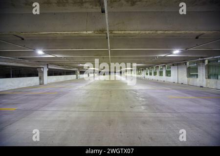 Empty Urban Parking Garage with Fluorescent Lighting, Symmetrical Perspective Stock Photo