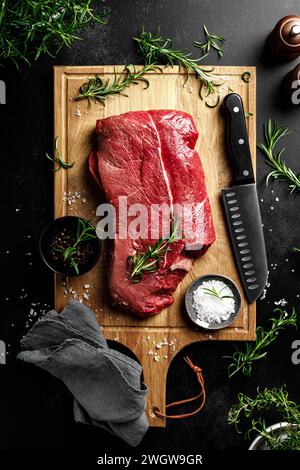 Beef meat entrecote on a cutting board, raw beef meat fillet on black background, top view Stock Photo