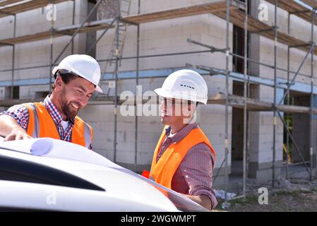 construction manager and architect on site during the construction of a house - planning and control on site - teamwork Stock Photo