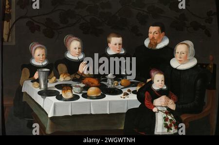 Prosperous Calvinist Family, anonymous, 1627 painting Family portrait of a couple with four children sat at a set table. On the table are plates with bread, roast poultry, a wine jug and a salt barrel. The two daughters on the left have folded their hands in prayer. On the right is the youngest child with a branch with cherries in the hand with the mother's lap. The rear wall is confiscated by a wine vend that grows through the window to the left. Northern Netherlands panel. oil paint (paint)  historical persons not known by name. anonymous historical persons portrayed in a group, in a group-p Stock Photo