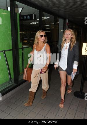 MIAMI, FL - SEPTEMBER 09: Spice Girl Geri Halliwell (L) arrives at Miami International Airport on holiday. After her recent bikini malfunction, you'd have thought that Geri Halliwell may now be a bit more careful her wardrobe choices. But her ample cleavage was on display once again today as she inadvertently showed off more than was probably necessary. The 38-year-old was dressed very strangely in a, peach-coloured velour tracksuit bottoms and brown suede boots.he clutched what looked like a brown school satchel and hid her eyes behind aviator sunglasses. Geraldine Estelle 'Geri' Halliwell Stock Photo