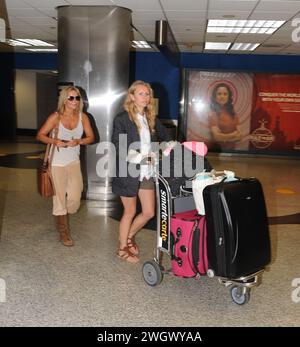 MIAMI, FL - SEPTEMBER 09: Spice Girl Geri Halliwell (L) arrives at Miami International Airport on holiday. After her recent bikini malfunction, you'd have thought that Geri Halliwell may now be a bit more careful her wardrobe choices. But her ample cleavage was on display once again today as she inadvertently showed off more than was probably necessary. The 38-year-old was dressed very strangely in a, peach-coloured velour tracksuit bottoms and brown suede boots.he clutched what looked like a brown school satchel and hid her eyes behind aviator sunglasses. Geraldine Estelle 'Geri' Halliwell Stock Photo