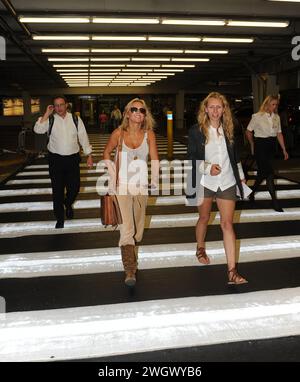 MIAMI, FL - SEPTEMBER 09: Spice Girl Geri Halliwell (L) arrives at Miami International Airport on holiday. After her recent bikini malfunction, you'd have thought that Geri Halliwell may now be a bit more careful her wardrobe choices. But her ample cleavage was on display once again today as she inadvertently showed off more than was probably necessary. The 38-year-old was dressed very strangely in a, peach-coloured velour tracksuit bottoms and brown suede boots.he clutched what looked like a brown school satchel and hid her eyes behind aviator sunglasses. Geraldine Estelle 'Geri' Halliwell Stock Photo