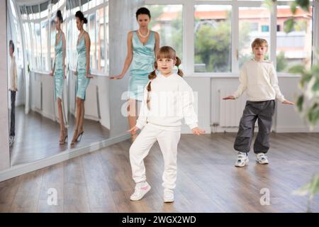 Preteen girl rehearsing funny Charlie Chaplin walk in choreography studio Stock Photo