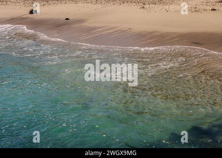 Ocean wave rolling onto sandy beach. Stock Photo