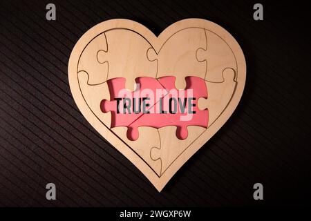 The text True Love appearing behind torn brown paper. Stock Photo