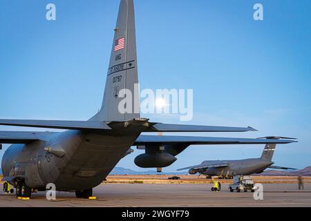 A U.S. Air Force C-130H Hercules aircraft, front, assigned to the 180th Airlift Squadron, Missouri Air National Guard and a C-5M Super Galaxy with the 22nd Airlift Squadron, sit on the flight line during Winter Training at the Advanced Tactics Training Center, Fort Huachuca, Arizona, January 25, 2024. Winter Training is a break from the regular course schedule where the instructors of AATTC tweak the training scenarios for the coming year and perform them, with the help of guest units, to keep their skills fresh. This is the first time that a C-5 has practiced tactics taught at the AATTC. Sinc Stock Photo