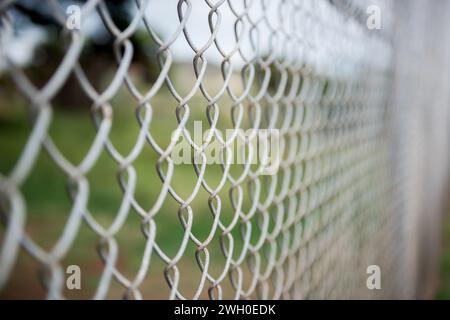Fence with metal grid in perspective. Metal chain-link fence as the background, street photo, close-up, Stock Photo