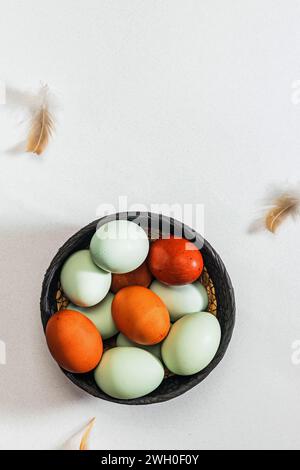 Variety of organic eggs and bird feathers, top view. Easter composition Stock Photo