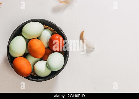 Heirloom eggs in a basket, top view, natural farming. Spring easter composition Stock Photo