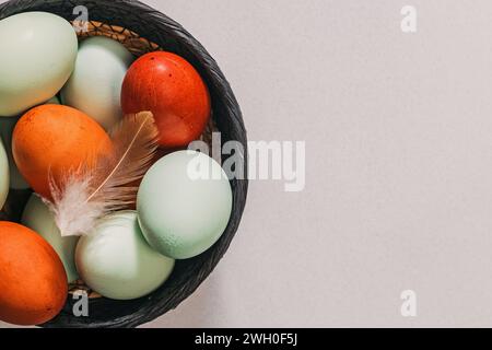 Variety of naturally colored blue and red eggs in a basket, eco natural farmers product Stock Photo
