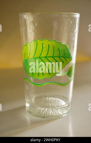 A glass cup with a green floral motif with a background that isolates it Stock Photo