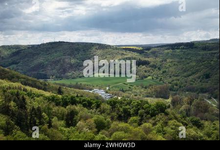 Bad Munster, Germany - May 12, 2021: Sun shining on a valley with green trees and grass in Rhineland Palatinate, Germany on a cloudy spring day. Stock Photo
