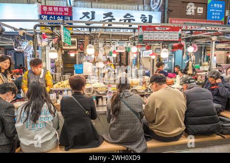 Seoul, South Korea - November 11, 2022 : shop and street food stall with many tourist at Gwangjang Market Stock Photo