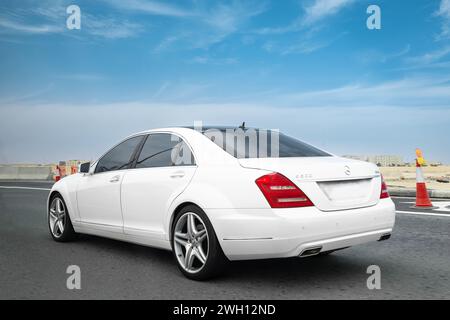 White Mercedes S500 on a test drive on a high way. Produced by the German automobile manufacturer Mercedes-Benz Group AG. Sport car. Luxury lifestyle- Stock Photo