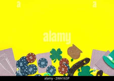 Poker chips with cards and decorations for St. Patrick's Day celebration on yellow background Stock Photo