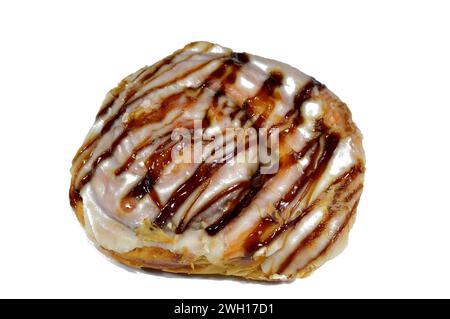 White chocolate and caramel sauce topping on a baked Danish pastry stuffed with honey sugary sweet syrup, sweet bakery dough baked in the oven with fl Stock Photo