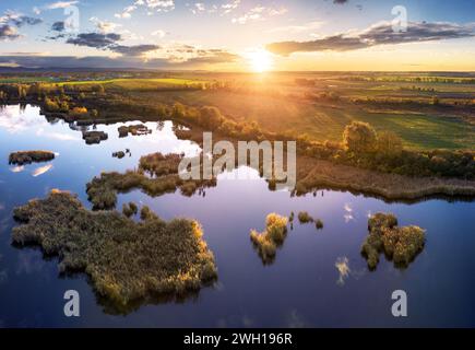 Forest Lake at sunset. Wild Lake in swamp, drone view. Rural landscape with lakes. Forest at bog. Stock Photo