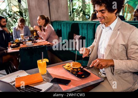 Businessman having lunch in restaurant. Stock Photo