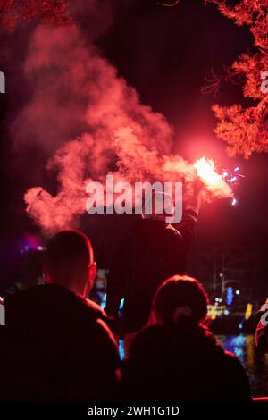 Man holding red torch with smoke to celebrate Stock Photo