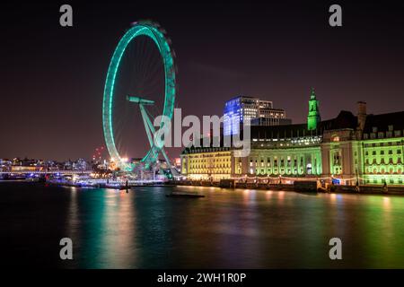 London. UK- 02.04.2024. A long exposure nigh view of the London Eye and County Hall casting light reflections on the Thames river. Stock Photo