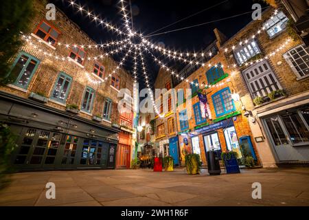 London. UK- 02.04.2024. A low, wide angle night time view of Neal's Yard showing the overhead lighting and Victorian warehouse architecture. Stock Photo