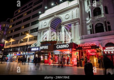 London. UK- 02.04.2024. A night time street view of Leicester Square looking at its many businesses catering for visitors and tourists. Stock Photo