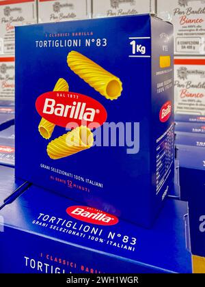 Italy - January 31, 2024: Tortiglioni macaroni Barilla pasta in classic blue cardboard box displayed on shelf for sale in Italian supermarket, Barilla Stock Photo