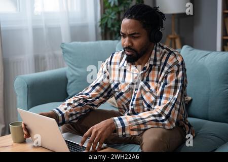 Young successful businessman sitting in home office preparing for video call presentation of product and marketing strategy. African American job seek Stock Photo
