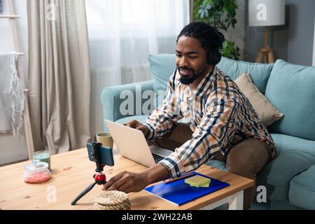 Young successful businessman sitting in home office preparing for video call presentation of product and marketing strategy. African American job seek Stock Photo