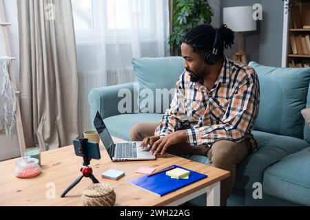 Young successful businessman sitting in home office preparing for video call presentation of product and marketing strategy. African American job seek Stock Photo