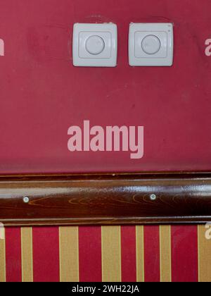 Two white power switch , on the red wall background. Part of pub interior. Stock Photo