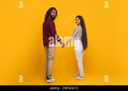 Back view of young indian couple holding hands Stock Photo