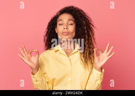 Relaxed african american woman doing yoga gesture Stock Photo