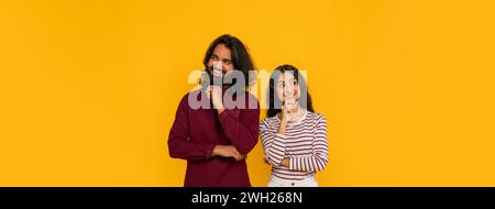 Curious young indian man and woman looking aside Stock Photo