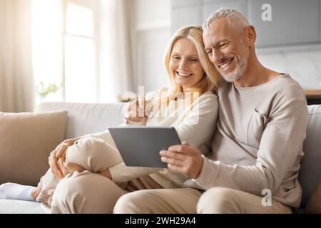 Happy Senior Couple Enjoying Digital Gadget World Using Their Tablet Stock Photo