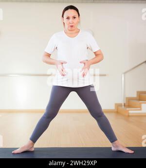 Pregnant woman is doing yoga in the gym Stock Photo