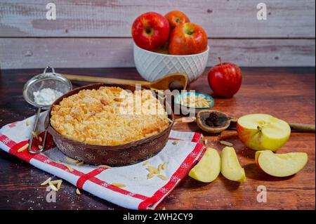 Freshly baked apple pie on a rustic kitchen worktop with ingredients and kitchen utensils. Stock Photo