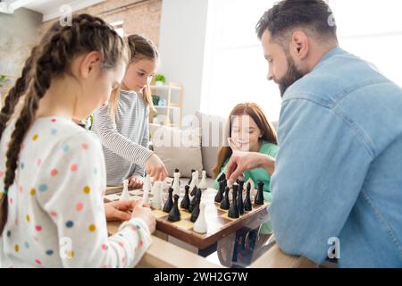 Portrait of nice intellectual focused cheerful family playing chess with alone dad free spare time at home house living-room indoors Stock Photo