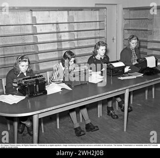 Learning to type in the 1940s. Four young women are  sitting at typewriters. A class and education in typing, using the right fingers and keys. 1942. Kristoffersson B117-4 Stock Photo